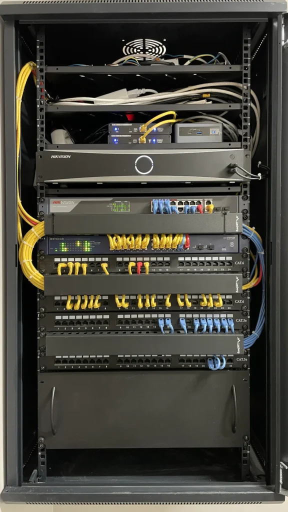 Wnętrze szafy RACK z rejestratorem monitoringu, switchami i patch panelami